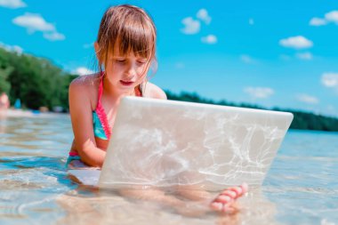 Her zaman ve her yerde öğrenmek. Güzel kız dışarıda tropikal denizde bilgisayarla uzaktan öğreniyor.. 