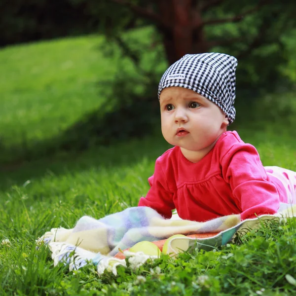 Surprised baby on green grass — Stock Photo, Image