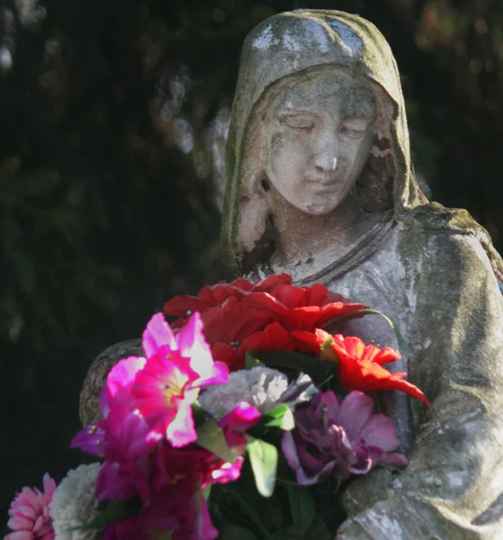 Standbeeld van Virgin Marywith de bloemen — Stockfoto