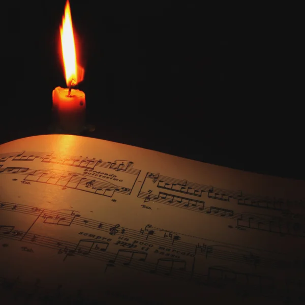 Musical notes by the light of candles — Stock Photo, Image
