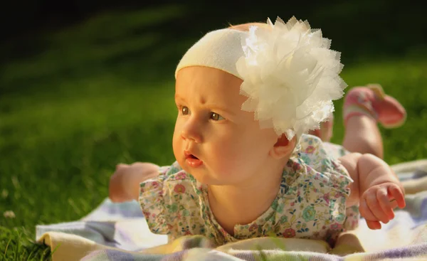 Surprised baby on green grass — Stock Photo, Image