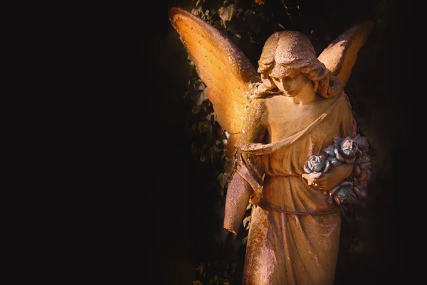 stock image sculpture of an angel with dark background