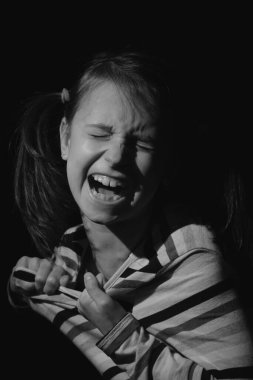 Kayıp çocukluk, akıl sağlığı, depresyon, panik ataklar ve çocuklarda endişe. Üzgün ve gergin bir kız çocuğu yardım için çığlık atıyor. Dikey resim.