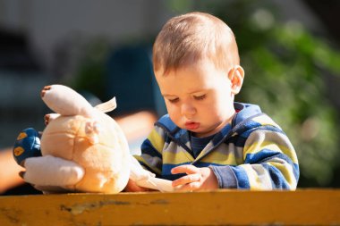 Kavramsal görüntü: Mutlu çocukluk. Yürümeye başlayan bir çocuk, hayatı oyun bahçesinde kahkahalarla kutlar..