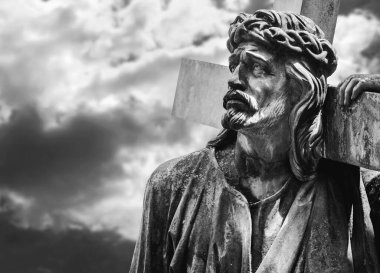 Bulutlu gökyüzünün çarpıcı manzarasına karşı haçlı antik İsa heykeli. Acı, acı ve diriliş konsepti. Siyah ve beyaz resim.