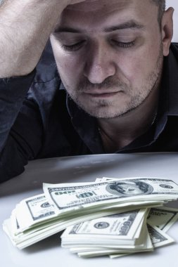 Amerikan Doları 'yla dolu yığınlar bir adamın önünde para getiriyor. Dikey resim.