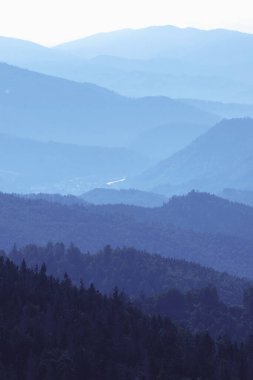 Mavi gökyüzüne karşı keskin uçurumlar ve siluetleri olan Carpathian kayalık derin geçidi. Dikey resim.