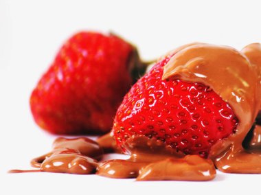Çilekleri çikolatayla kaplayıp beyaz arka plana koy. Lezzetli yemek. Yatay resim.