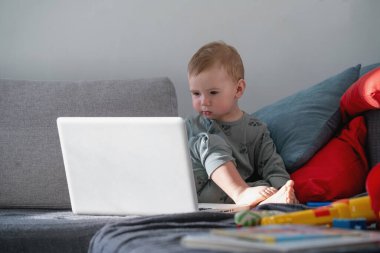 Bir bilgisayar ekranındaki dijital içerikten büyülenen çocuk..