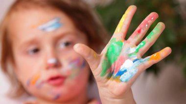 Boyayla kaplı renkli bir çocuğun yakın çekimi saf yaratıcılık ve hayal gücünün bir sembolüdür.