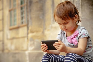 Modern teknolojiye sahip bir çocuğun samimi anı. Uzayı kopyala Yatay resim.