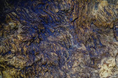 Yıpranmış yüzeyi ve mineral tonlarıyla antik taş dokusu zamanı, tarihi, dayanıklılığı ve doğal jeolojik güzelliği sembolize eder..