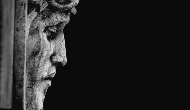 Karanlıktan çıkan taş heykel yüzü sessizliği, kederi, tefekküre dalmayı ve insani duyguları simgeliyor. Metin veya tasarım için boşluk kopyala.