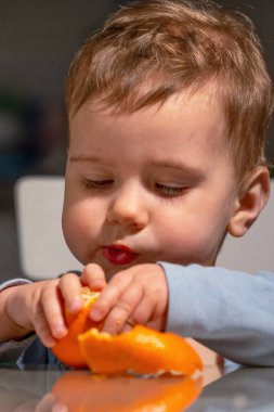 Yürüyen çocuk mandalina yerken kontrol ve koordinasyon öğreniyor..