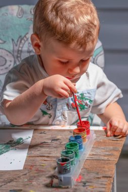 Çocuk masada yaratıcı aktiviteler yaparak öğreniyor..