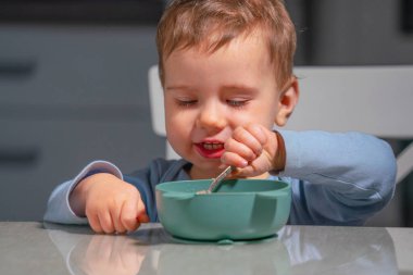 Bebek besleyici bebek maması yerken sağlıklı bir kahvaltı..