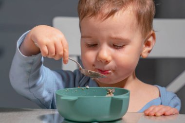 Çocuk günlük yulaf ezmesi kahvaltısıyla sağlıklı yemek rutinini öğreniyor..