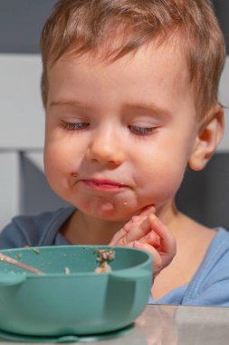 Bebek masada sağlıklı yulaf ezmesi yerken sabah rutini..