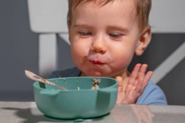 Yürüyen çocuk, koordinasyon ve konsantrasyon becerilerini geliştirirken kahvaltıya odaklandı..