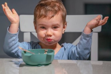 Yürüyen çocuk sakin kahvaltı saatlerinde günlük kişisel bakım becerilerini öğreniyor..