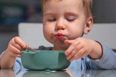 Dengeli çocuk beslenmesinin bir parçası olarak yulaf ezmesi yiyen bir çocuk..