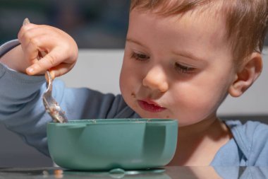Yürüyen çocuk kendini beslerken kahvaltıya odaklanmış..