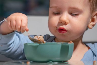 Erken öğrenme rutininin bir parçası olarak yulaf ezmesi yiyen çocuk..