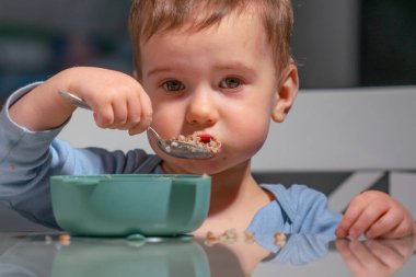 Çocuk günlük rutin olarak mısır gevreği yemeye odaklanmış..