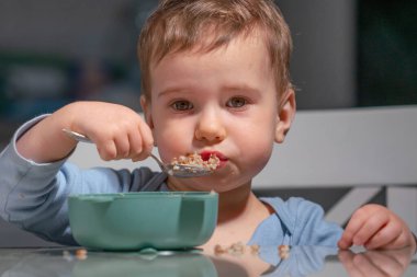 Bağımsız çocuk sağlıklı yaşam tarzının bir parçası olarak yulaf ezmesi yiyor..