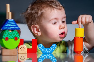 Yaratıcı oyun sırasında ahşap bloklarla konsantre olan çocuk, erken bilişsel gelişimi destekliyor.