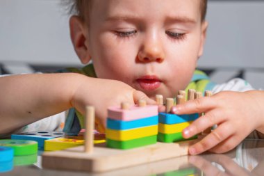 Küçük çocuk duyusal tahta oyuncaklarla parmak kontrolü yapıyor..