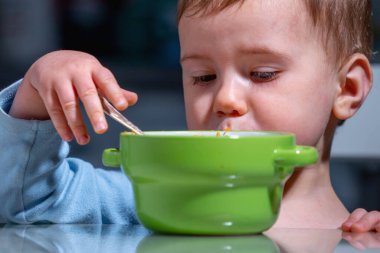 Sevimli bebek elma salatası ve portakal, kivi, havuç ve muz yiyor..