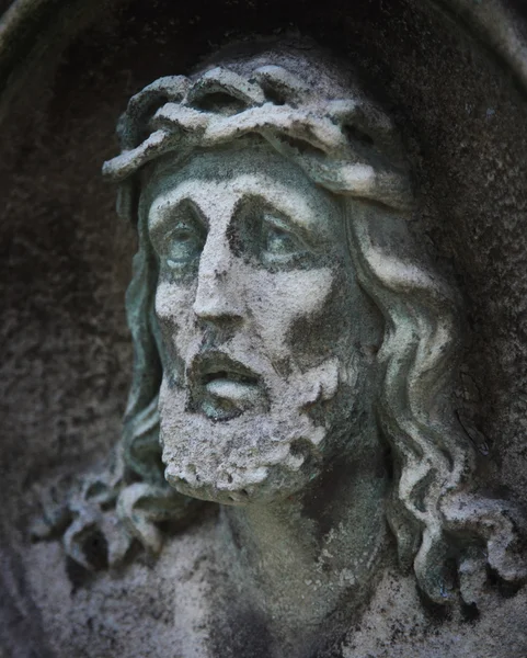 Standbeeld van Jezus Christus tegen een achtergrond van grijze steen — Stockfoto