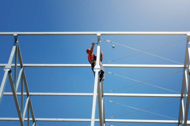 Demir İşçileri, şehirde inşaat halindeki uzun apartmanın inşaat iskeleti üzerinde çalışıyorlar..