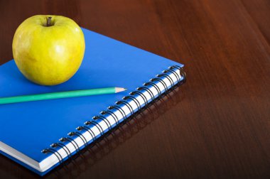 Ahşap masa üzerinde apple ile okul malzemeleri