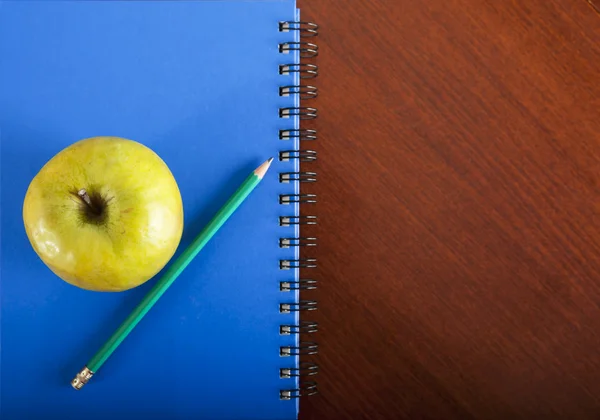 School supplies with apple on wooden table — Stock Photo, Image