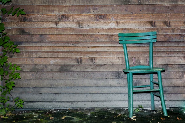 Cadeira de madeira contra parede de madeira — Fotografia de Stock