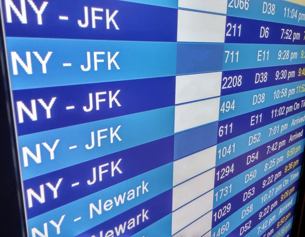 Arrivals display board at airport terminal — Stock Photo, Image