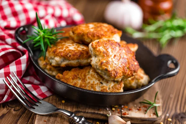 Costeletas de carne na frigideira na mesa rústica de madeira — Fotografia de Stock