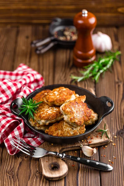 Meat cutlets in frying pan on wooden rustic table — Stock Photo, Image