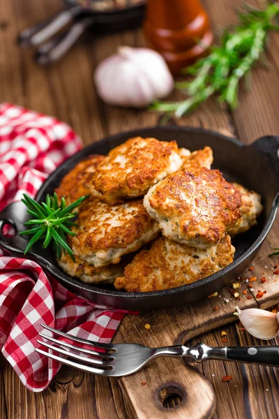 Meat cutlets in frying pan on wooden rustic table — Stock Photo, Image