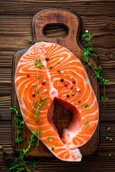 Bistecca di pesce crudo di salmone su sfondo rustico in legno — Foto Stock