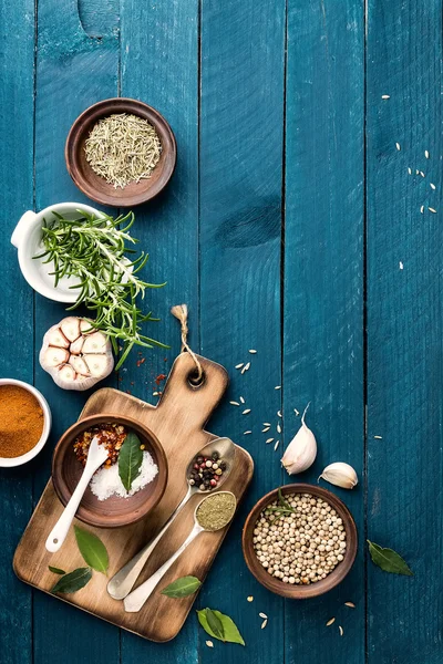 Culinaire achtergrond met kruiden op houten tafel — Stockfoto