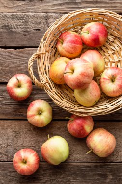 Hasır sepet ahşap masa üzerinde taze kırmızı elma.