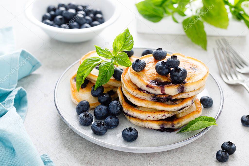 Blueberry pancakes with fresh berries on breakfast table