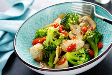 Tavuk, sebze ve mantarla birlikte kızarır.