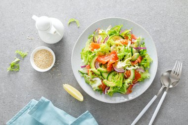 Tuzlu balıklı somon avokado salatası, taze marul ve kırmızı soğan.