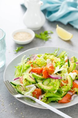 Tuzlu balıklı somon avokado salatası, taze marul ve kırmızı soğan.