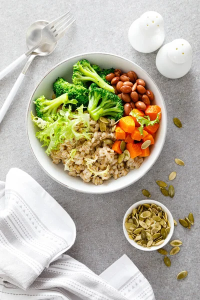 Vegetarian lunch bowl with pearl barley, red beans, broccoli and butternut squash