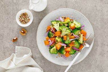 Fırında kabak, kırmızı soğan ve cevizli vejetaryen brokoli salatası.